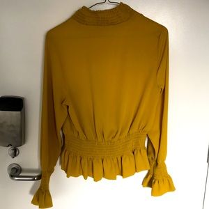 Ochre blouse with elastic waist and sleeves.